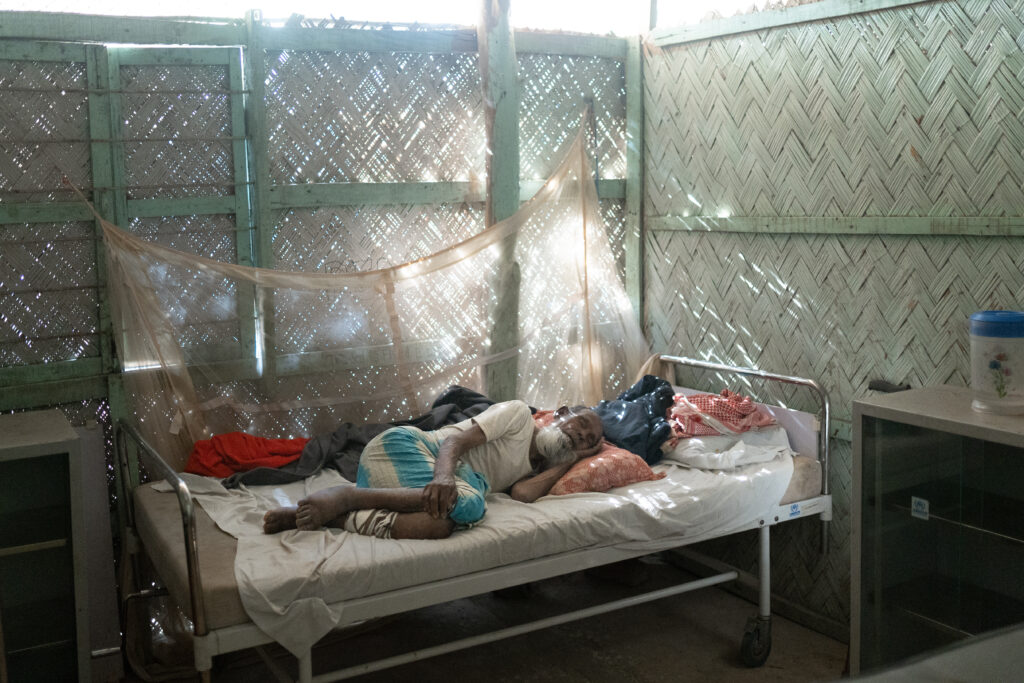 A man lays in bed in a Medical Teams clinic in Bangladesh.