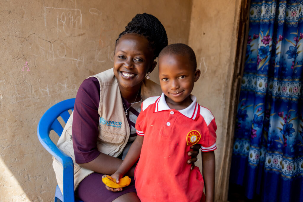 Racheal Kyalikoba and a young child smile together.