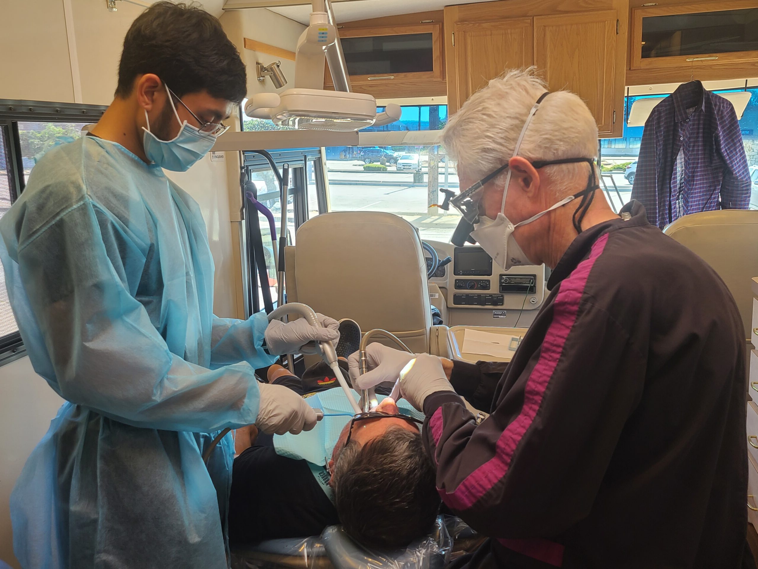 A dentist and dental assistant performing a procedure on Sjon Scarborough.