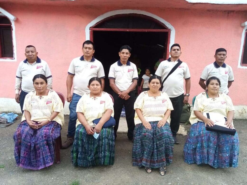 A group of men (standing) and women (sitting) pose for a photo.