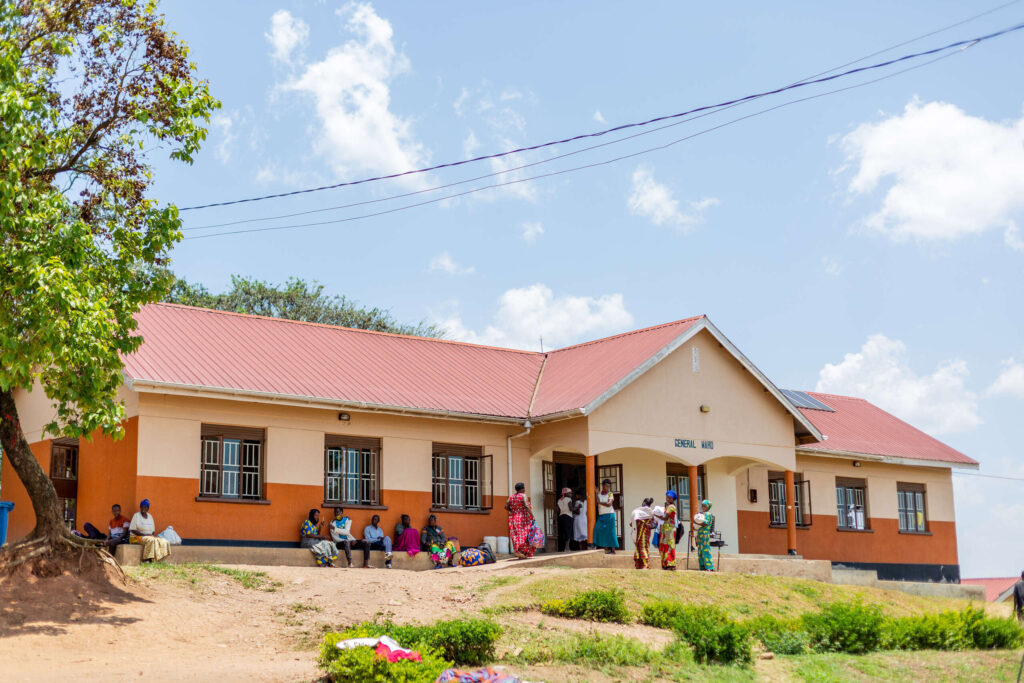 A medical facility with people sitting and standing in front of it.