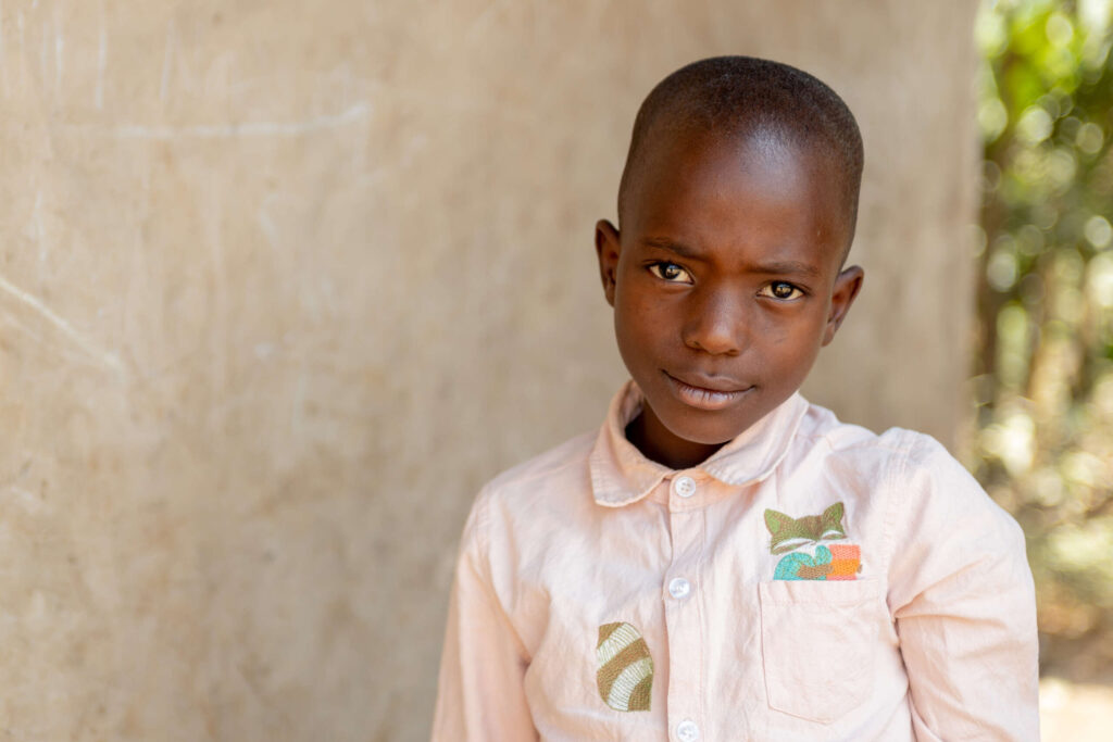 Thiery stands next to a wall outside his home.