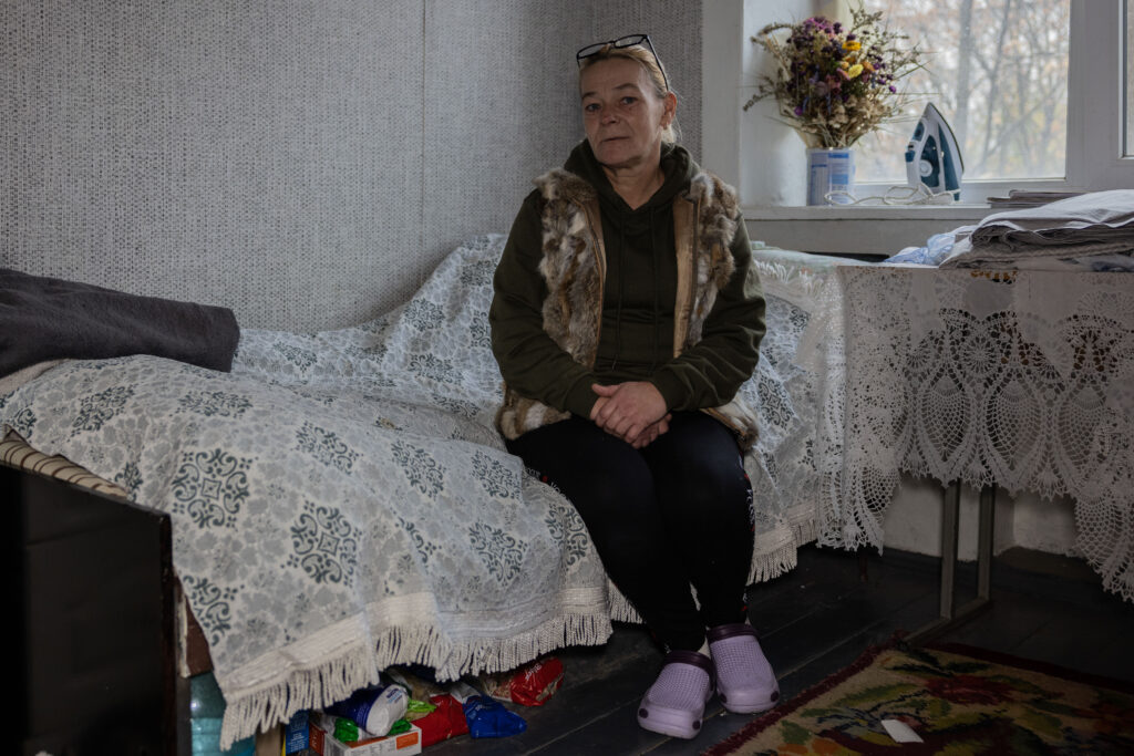 Ukraine photo: a woman sitting on her bed, arms folded in her lap
