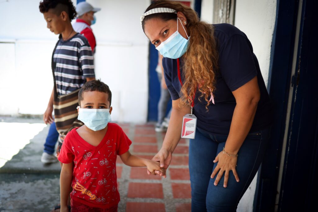 Margri holds hands with one of the children in the community in Colombia. Nikki Lerner is inspired by women like Margri!