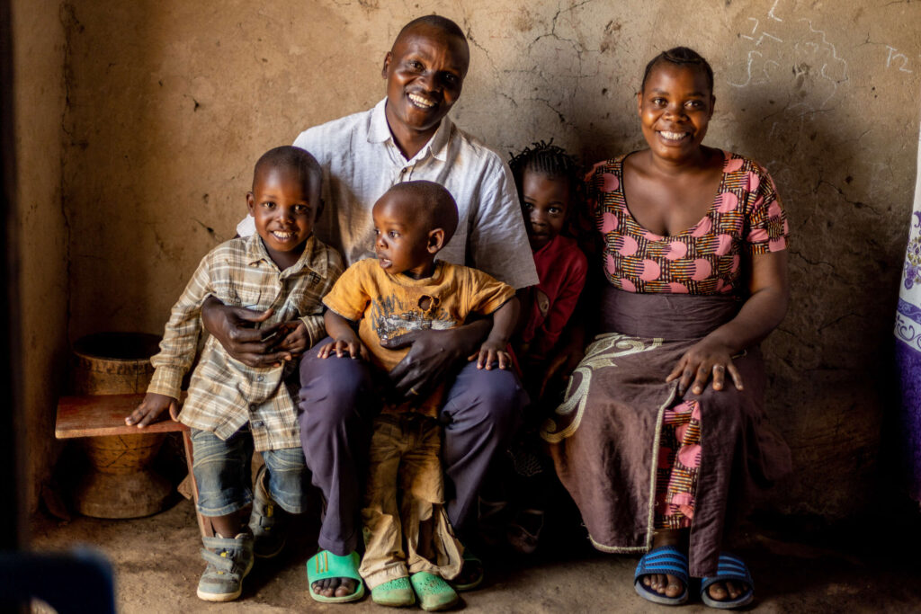 A family smiles together in their home.