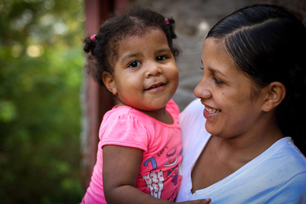 A mother and her young daughter smiling