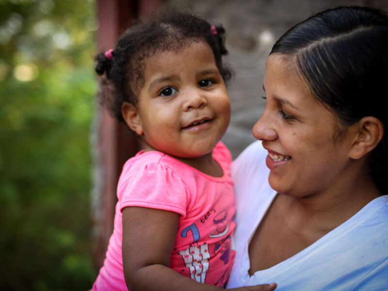 A mother and her young daughter smiling