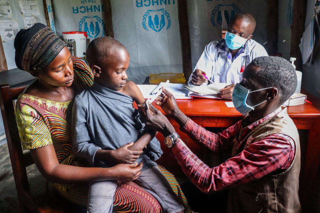 A nutritionist examines a young boy for malnutrition.