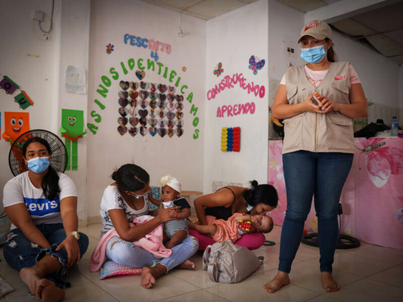A Medical Teams staff person teaching a mother and child
