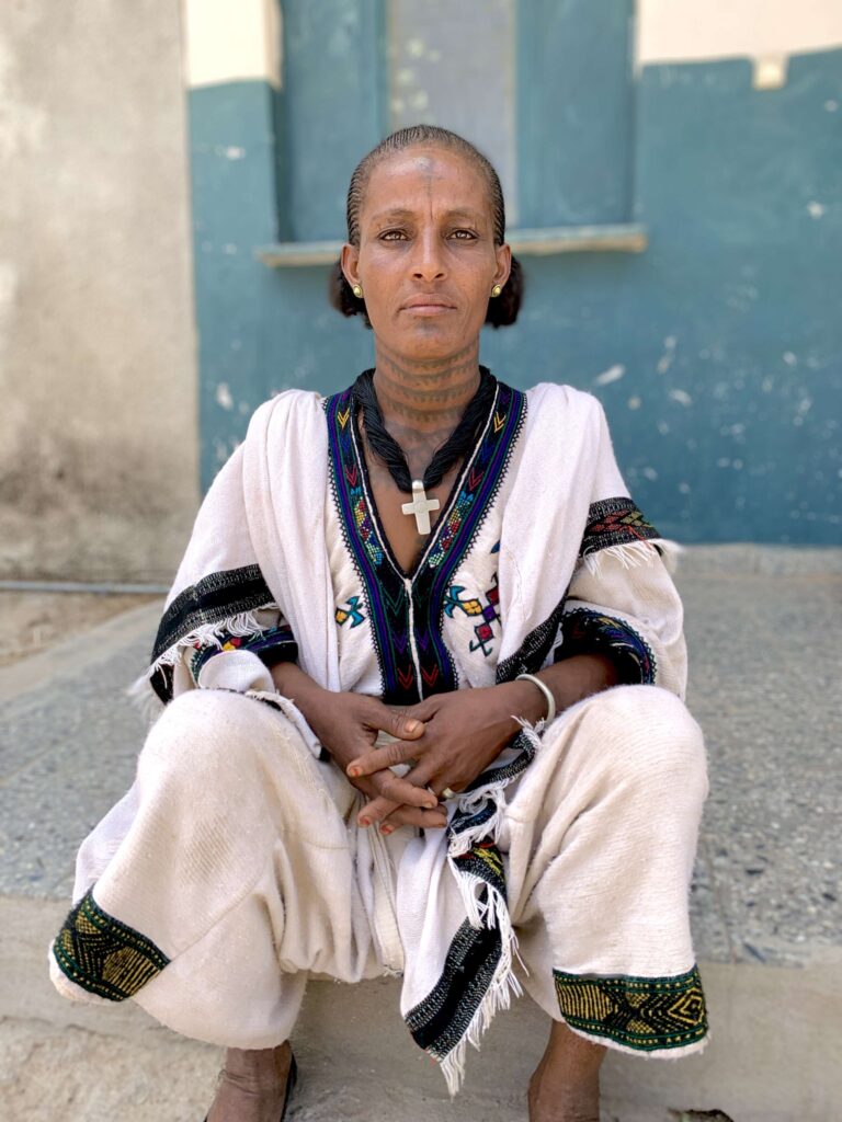 A woman in Ethiopia sits outside a clinic where she was treated for repeated infections.