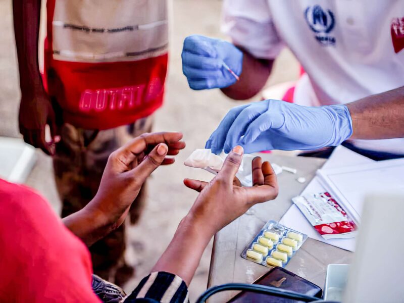 close-up of gloved hands treating a patient