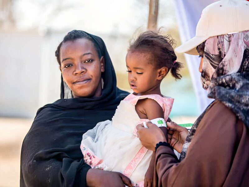 Mother and daughter being checked by staff at the mobile medical team