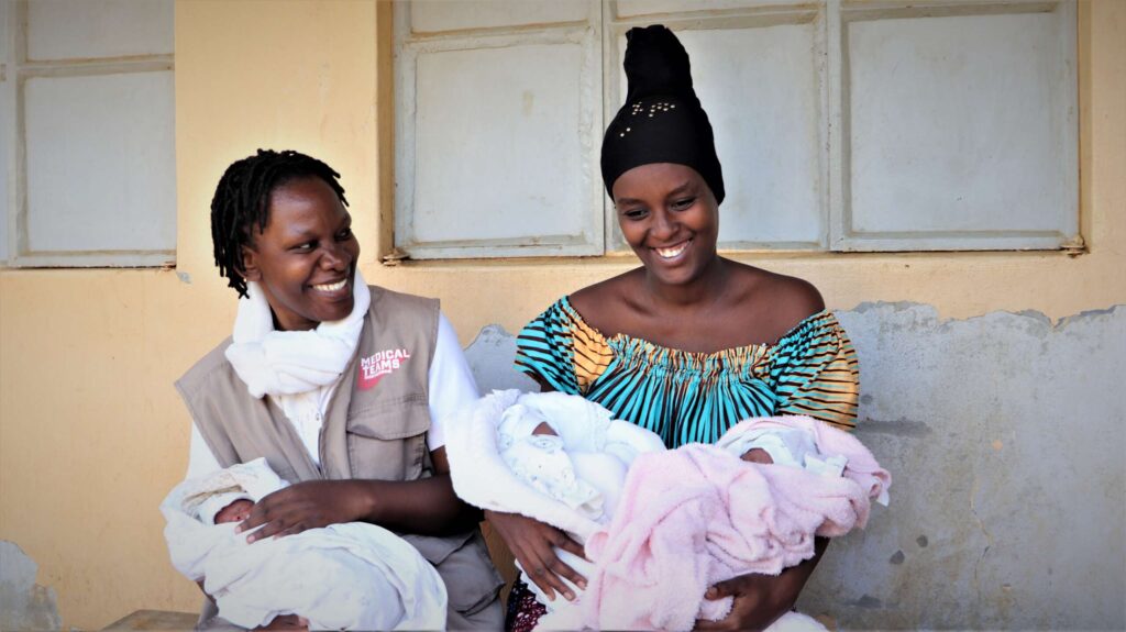 A new mother holds her babies and could benefit from a gift from our gift catalog