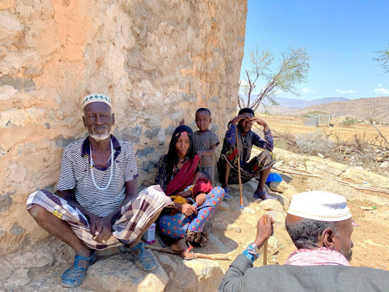 The Ali family sitting outside their house, 2023