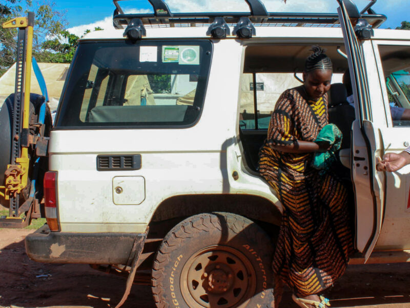 Referral patient stepping out of car at health screening.