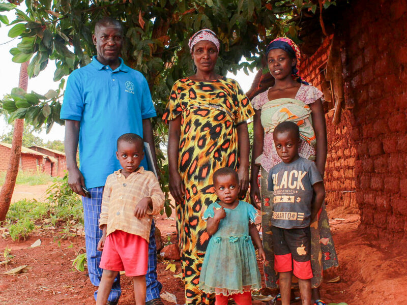 Bapfumukeko with husband and children outside their house. Maternal Health story, Bleeding case.