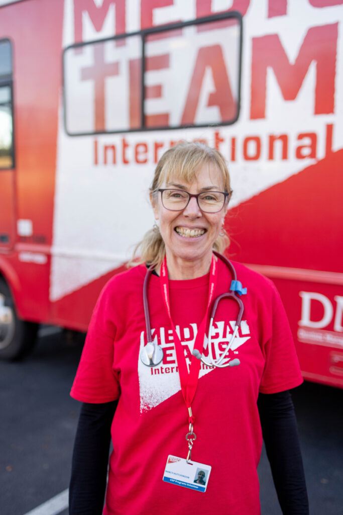 Volunteer Nurse in front of the Medical Teams Dental Van