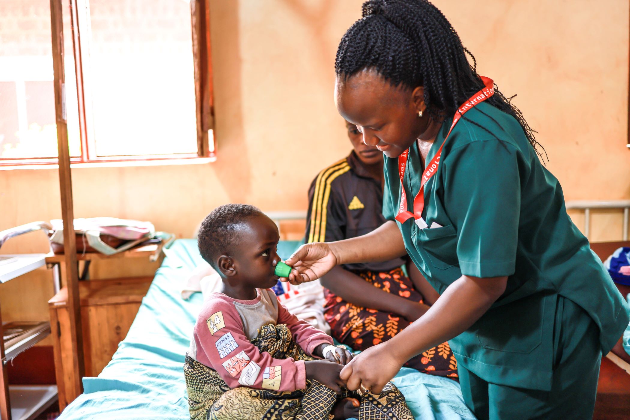 A Medical Teams Health Worker gives medication to Niyukuri in Tanzania