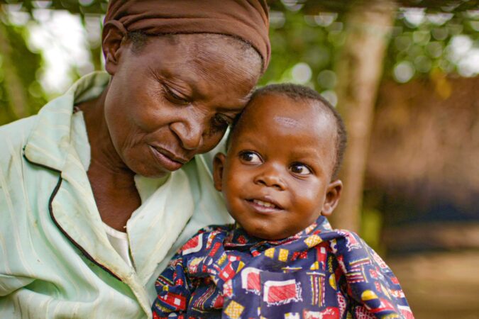 David sits with his grandmother in Uganda