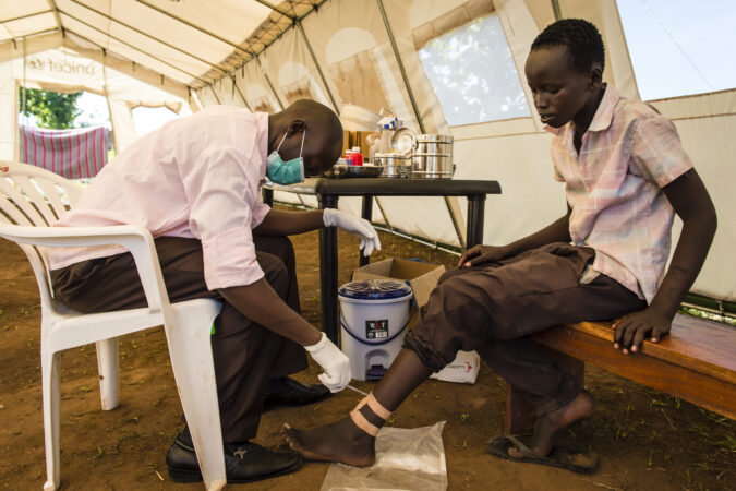 A health worker cares for an injured patient in Uganda, 2014