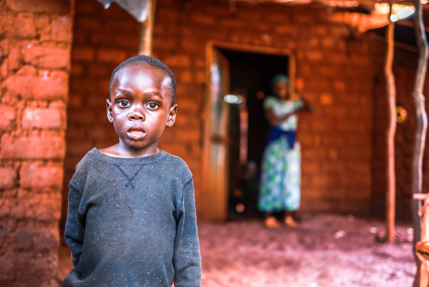 Niyukuri standing outside his home in Tanzania