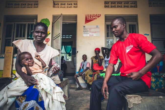 A mother and daughter, Brenda and Sabrina, meet with a health worker for malaria treatment in Uganda, 2017