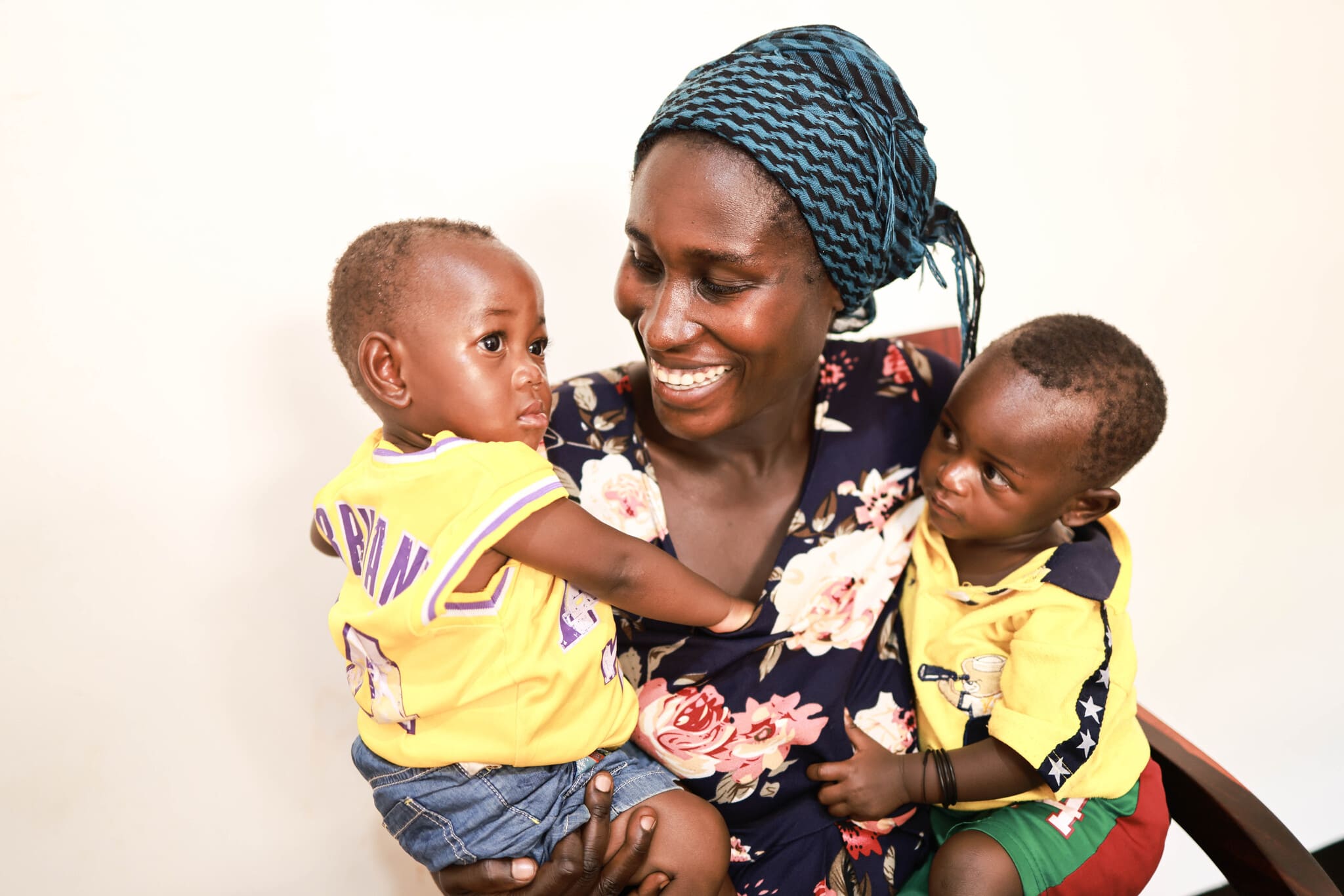 Minani Janeth smiles while holding her twin babies in a clinic in Tanzania