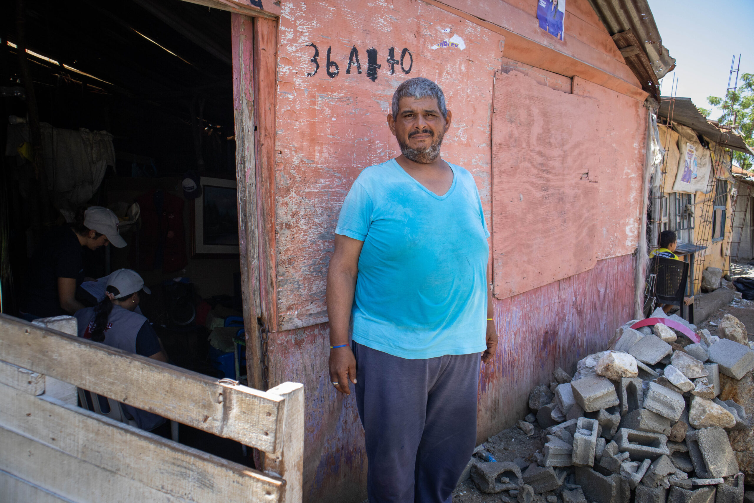 Luis standing outside his home. 