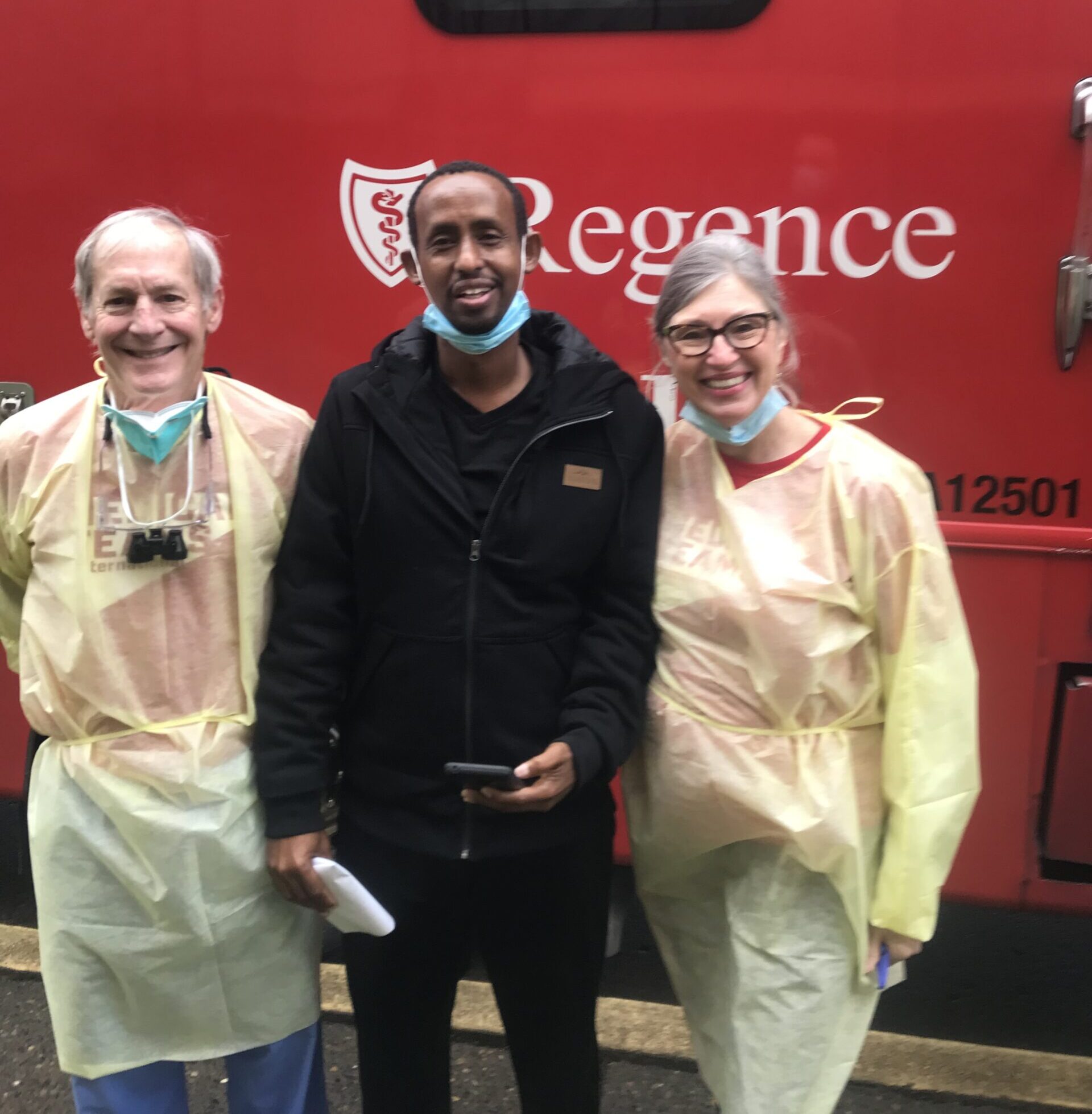 Dr. Kurt and Kathi Karnosh smile with a Somali patient outside a dental clinic