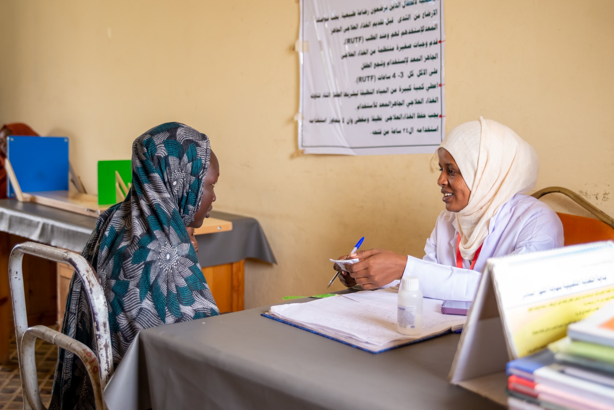 Fatima speaks with a nutrition assistant in Sudan