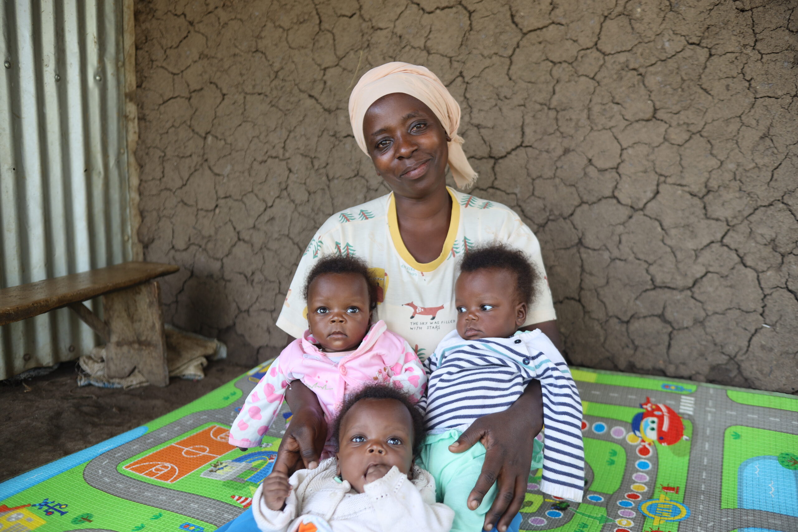 Nzariturike at home with her triplets.