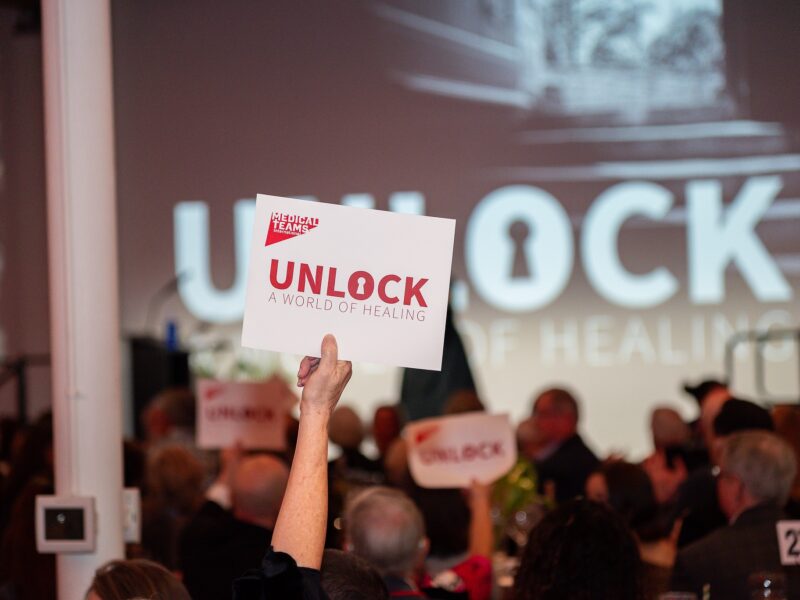 A guest holding up a bidding paddle.