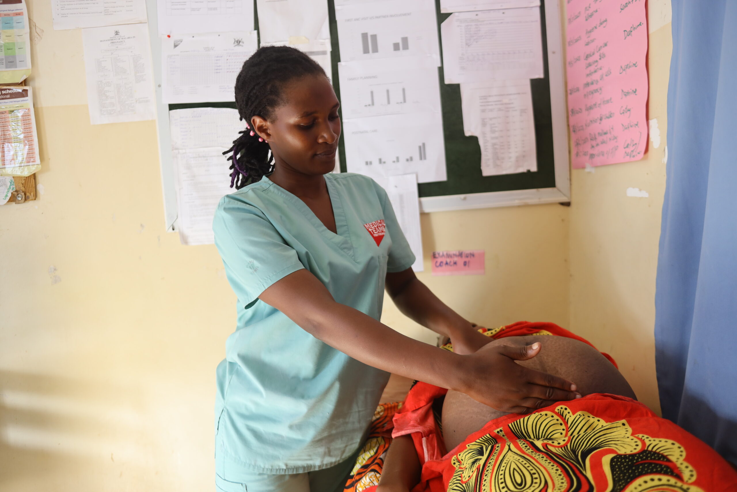 Midwife Daphine examines a mother in the Kyangwali settlement. 