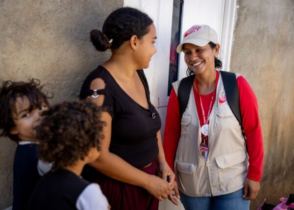 A community health volunteer named Maria visits with a woman named Nelimar and her children at their home in Colombia.
