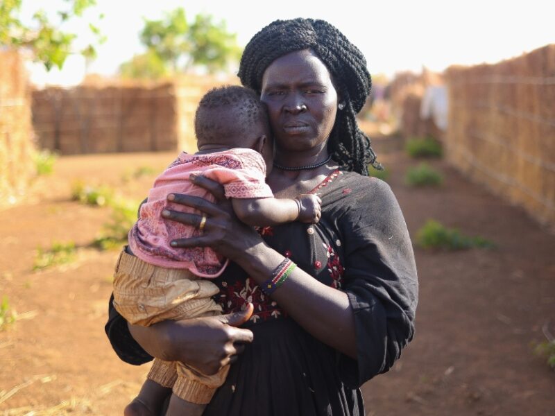 Kinana holds her child outside in Ethiopia
