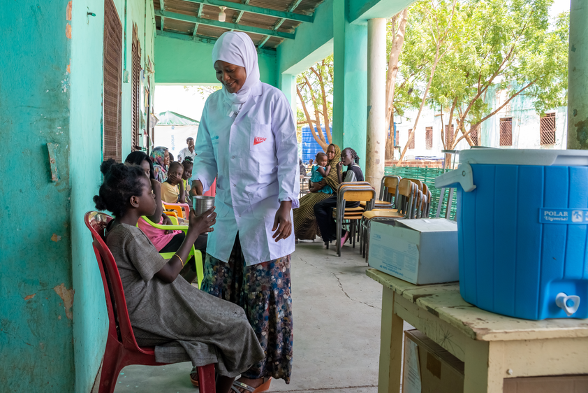 Nurse Mazahir providers an oral rehydration solution to a girl in Sudan.
