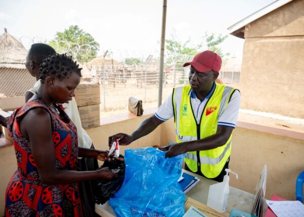 A mother in Uganda receives supplies for feeding her child from a Medical Teams staff member.