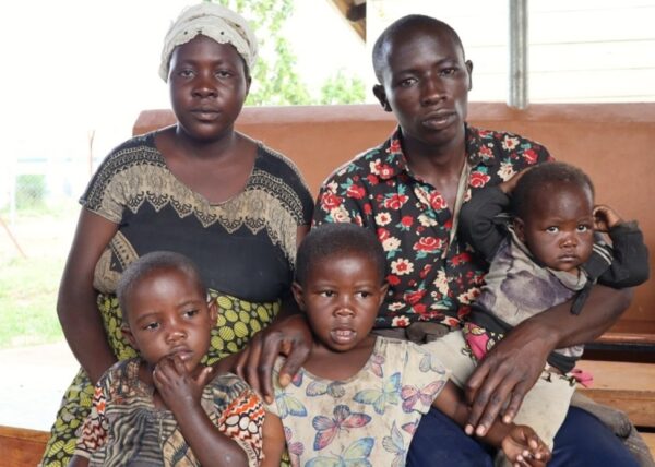 Masengsho sits with his wife Chance and three children in Uganda