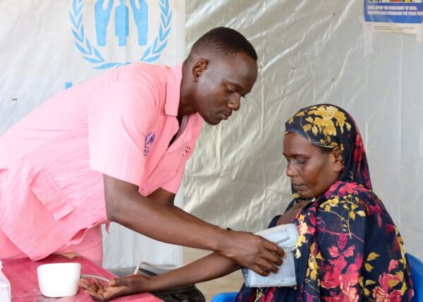Nurse Henry checks the blood pressure of a patient in Uganda