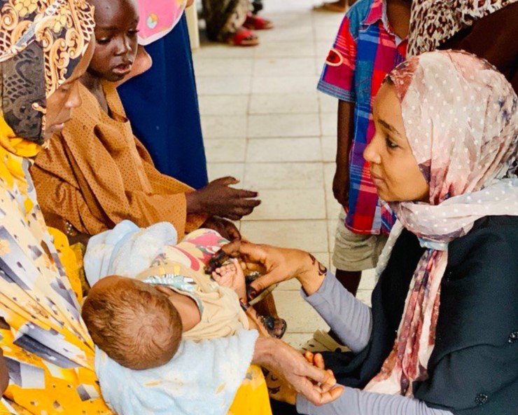 Asma with a patient and her baby. 