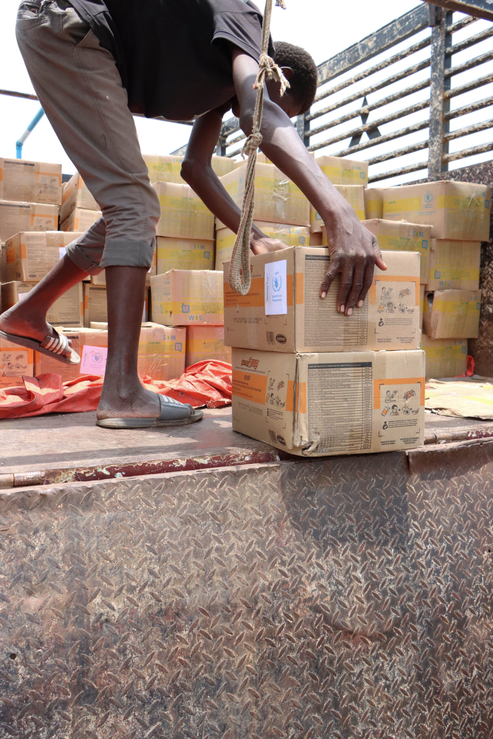A worker loading supplies into a transport truck in Sudan.