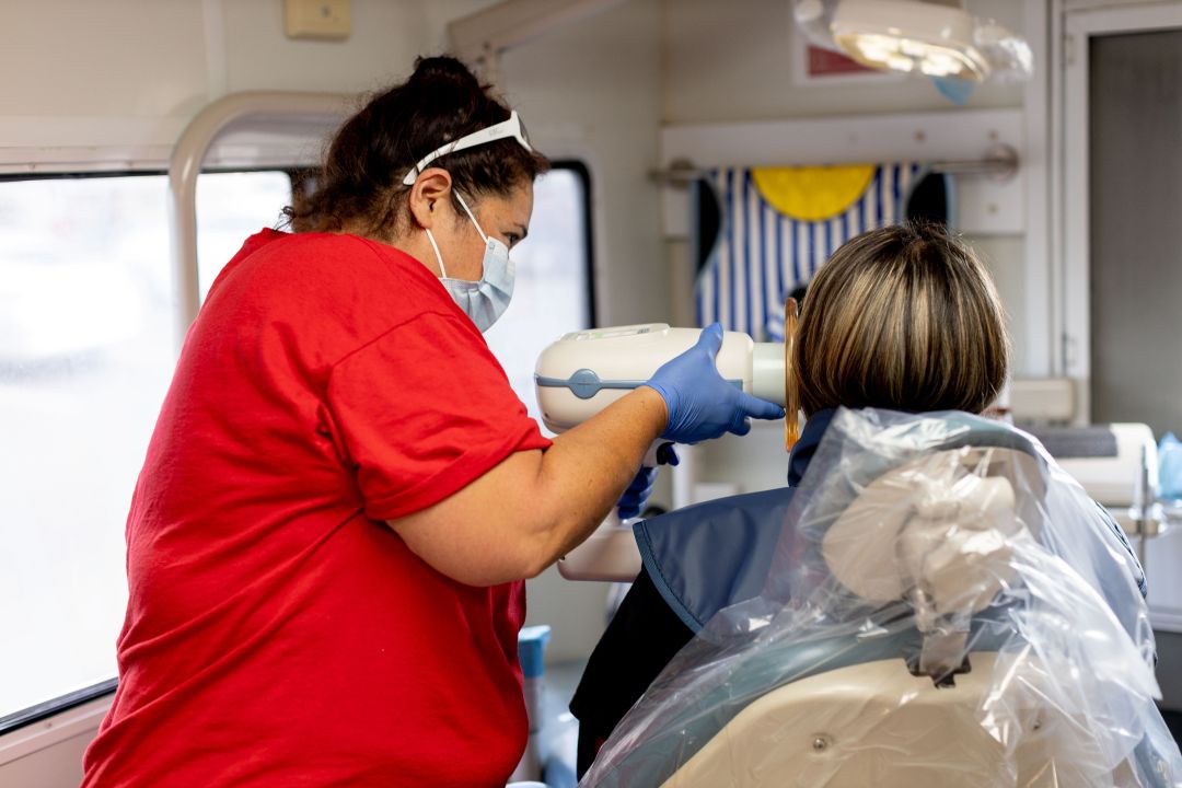 A Medical Teams health worker takes an x-ray at a dental office visit in the U.S.