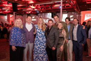Group of men and women pose together at gala.