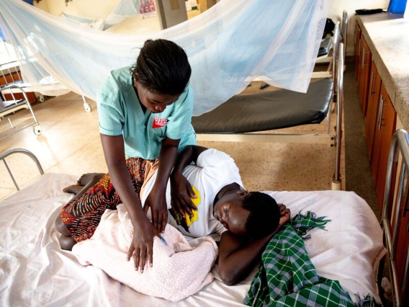 A Medical Teams nurse tends to a patient and her newborn in Uganda