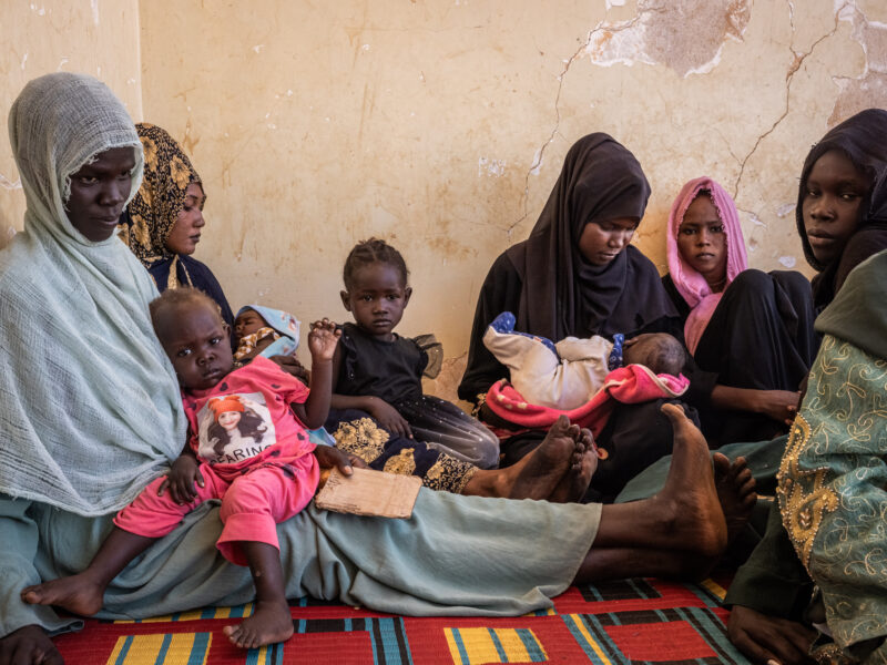Women wait with their children to get their health assessed.