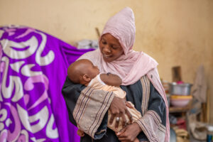 Mother smiles down at baby
