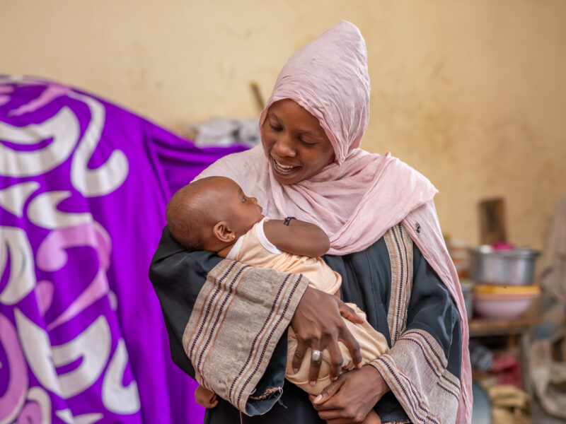 Mother smiles down at baby