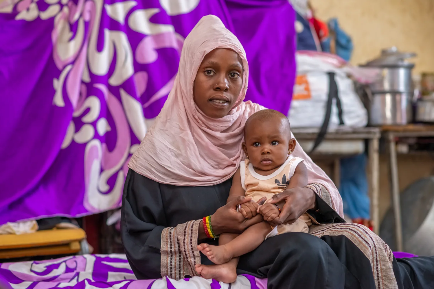Baby Jackline on her mother Katrina's lap in Sudan.