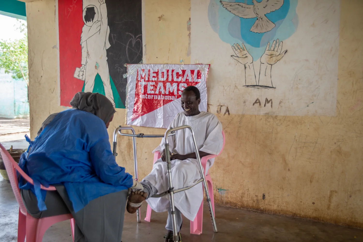 Saif similing while a nurse is dressing his wound in Sudan.